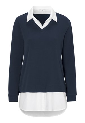 Marineblauer Pullover mit V-Ausschnitt und langen Ärmeln, über einem weißen Hemd getragen. Weicher Stoff, lockere Passform und abgerundeter Saum unten.