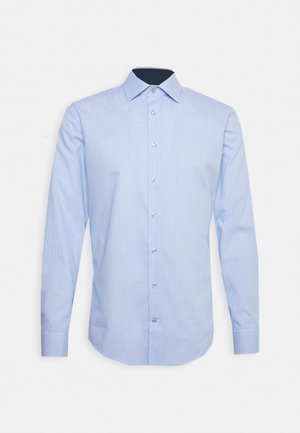 Camicia a maniche lunghe azzurro chiaro con motivo a scacchi, chiusura a bottoni e colletto a pois blu scuro. Presenta bottoni trasparenti e un orlo dritto.