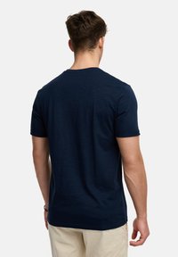 Tricou confortabil, cu mânecă scurtă, de culoare bleumarin, design cu guler rotund, realizat dintr-un material moale, cu o textură netedă și detalii minime de coasere pe spate.