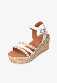 Sandalias de cuña blancas con tiras, con una plataforma de yute trenzado, plantilla acolchada marrón y un detalle de hebilla plateada en la tira del tobillo.