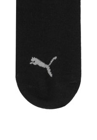 Schwarze Socke aus einer Baumwollmischung, mit einem weißen Puma-Logo nahe der Zehe. Glatte Textur mit einem Design in Standardhöhe.