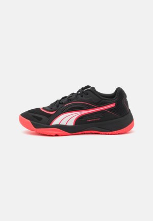 Black athletic shoe featuring a textured upper, pink and white accents, a rounded toe, and a rubber outsole for traction and stability.