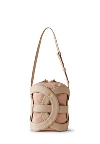 Beige textured bag with a smooth finish, featuring a curved strap and decorative, interlocking straps. Metallic accents are present.
