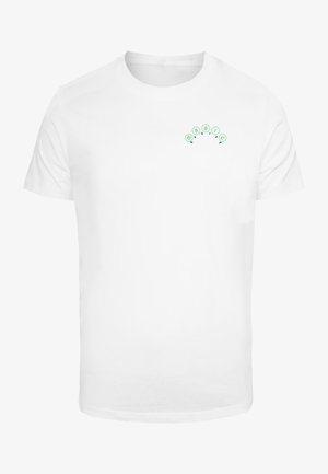 Balts kokvilnas T-krekls ar nelielu zaļu grafiku, kurā ir teksts "MAGIC" izliekta dizainā augšējā kreisajā krūšu daļā.