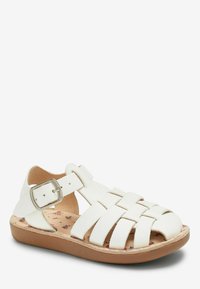 Weiße Ledersandalen mit geflochtenen Riemen, verstellbarem Schnallenverschluss und einer gepolsterten Innensohle mit floralem Muster. Hellbraune Gummisohle.