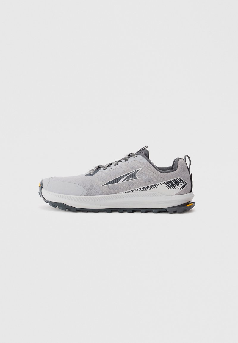 Gray athletic shoes with a mesh upper, contrasting black accents, rugged sole, and reflective logo detailing. Designed for traction and durability.