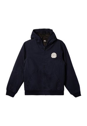 Chaqueta con capucha de color navy, con cremallera frontal, puños acanalados y dos bolsillos laterales. Presenta un logo circular en el lado izquierdo del pecho. Textura suave.
