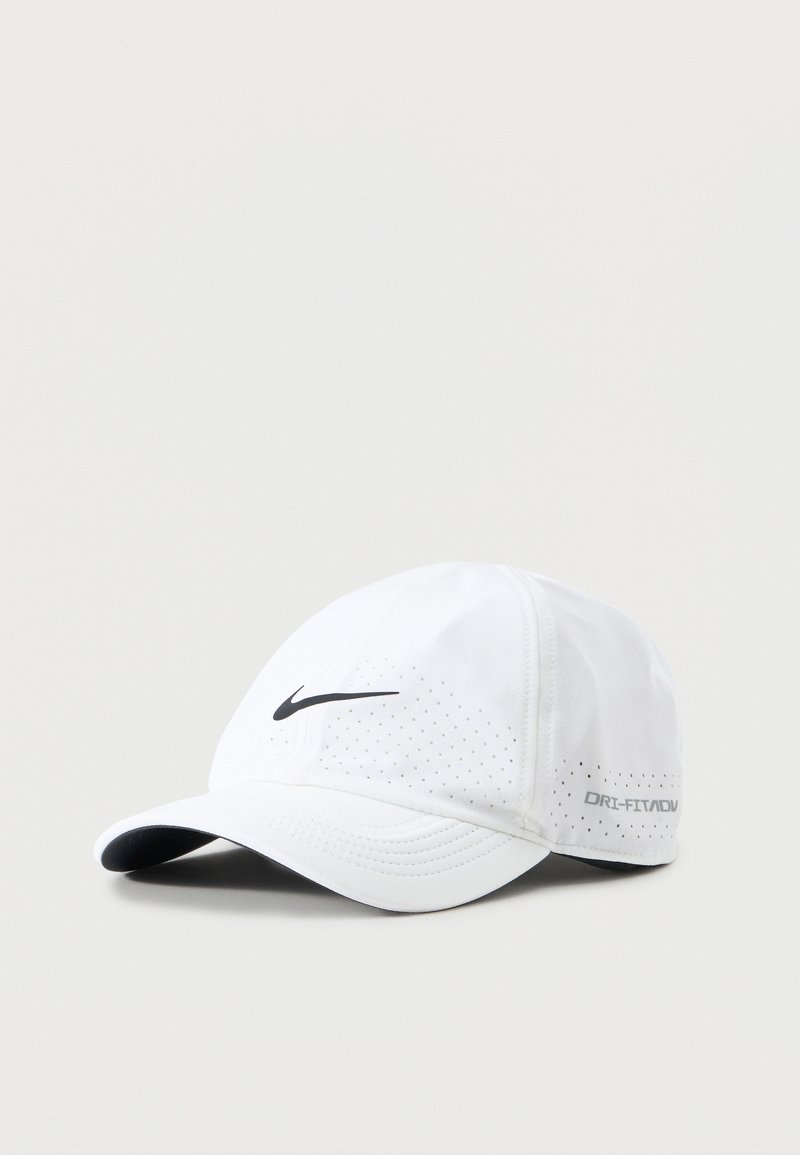 Λευκό καπέλο μπέιζμπολ Nike Dri-FIT ADV με μαύρο λογότυπο swoosh και οπές αερισμού σε απλό ανοιχτό φόντο.
