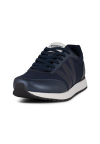 Zapatilla deportiva azul marino con parte superior de malla, acentos de cuero, suela intermedia gruesa blanca y suela de goma; presenta un logo en la lengüeta y en el lado.