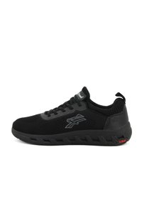 Scarpa sportiva nera con tomaia in rete, suola in gomma e collo imbottito. Presenta accenti a strati e logo laterale. Superficie testurizzata.