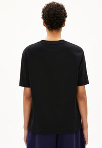 Zwart katoenen t-shirt met korte mouwen en een klassieke ronde hals. Het heeft een soepele textuur en een relaxte pasvorm met omgezoomde mouwen.