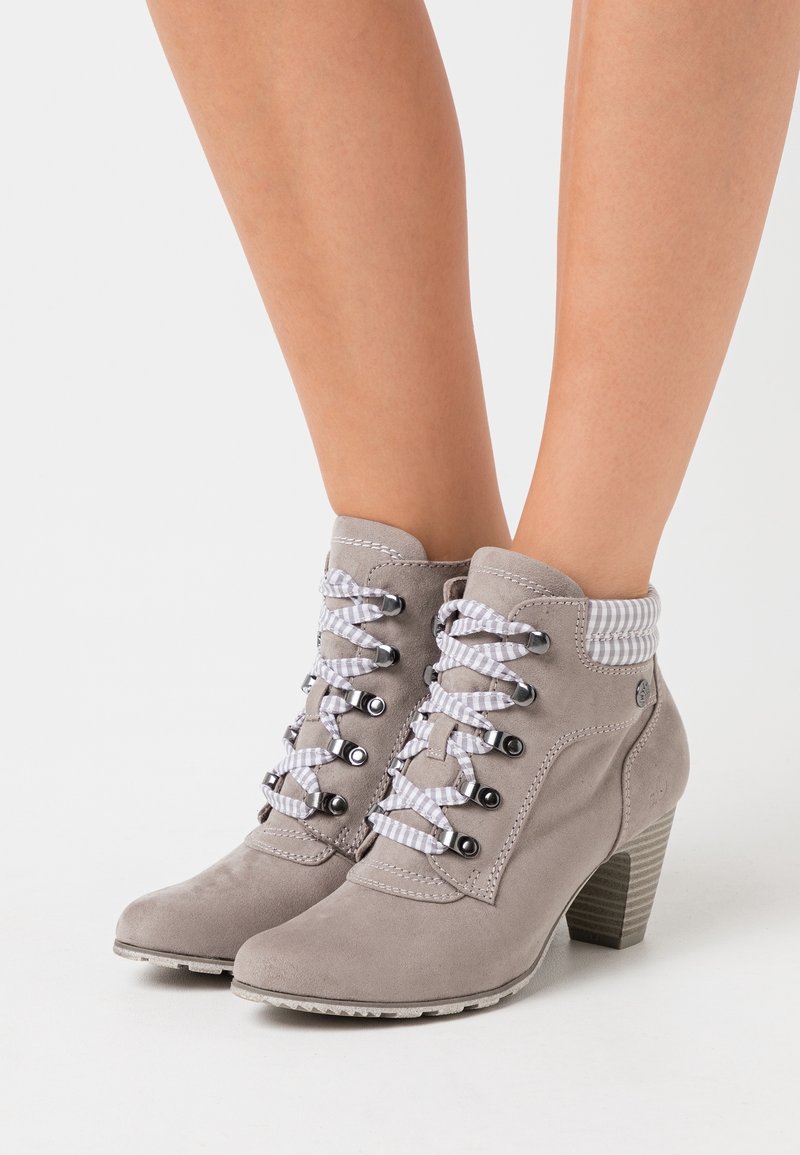 Botas de tobillo de ante gris con un upper texturizado, que presentan cordones de rayas grises y blancas y un tacón apilado. El collar texturizado acentúa el diseño.