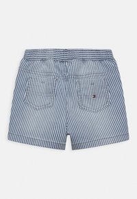 Striped denim shorts in blue and white, featuring a gathered waistband and two back patch pockets with logo detail.