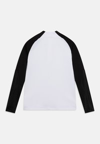 Maglietta a maniche lunghe con corpo bianco e maniche raglan nere, con dettagli neri testurizzati. Tessuto morbido, colletto tondo e orlo dritto.