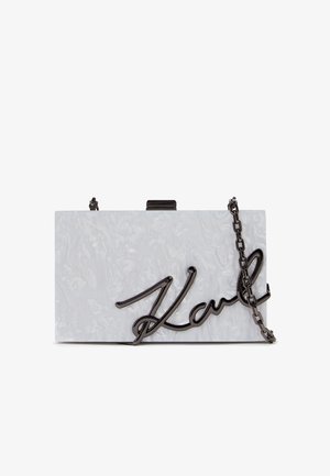 Pochette rectangulaire blanche à texture marbre avec une chaîne noire en bandoulière et le logo "Karl" en lettres cursives noires sur le devant.