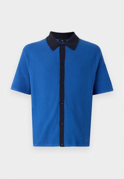 Short-sleeve polo shirt in vibrant blue with a dark blue button placket and collar. Textured fabric with a smooth finish, featuring five buttons.
