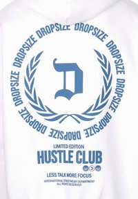 Bijela kapuljača s plavim grafičkim elementima, uključujući stilizirano slovo "D", dizajn laurusa i natpis "HUSTLE CLUB" i "LIMITED EDITION."