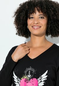 Schwarzes V-Ausschnitt Langarmshirt mit einem grafischen Design eines pinken Herzens mit Flügeln und Akzentdetails. Weicher Stoff, lässige Passform.