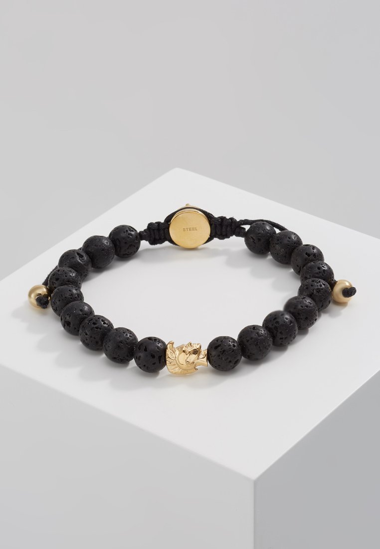 Schwarzes Lava-Stein-Perlenarmband mit einem goldenen Akzentstück in Form eines Blattes, gesichert mit einem schwarzen verstellbaren Kordel.