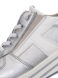Close-up of silver and white leather sneaker with white laces, elastic side panel, and textured rubber sole.