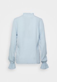Blusa azzurro chiaro a maniche lunghe con polsini arricciati e collo alto arricciato, mostrata di spalle su uno sfondo semplice.