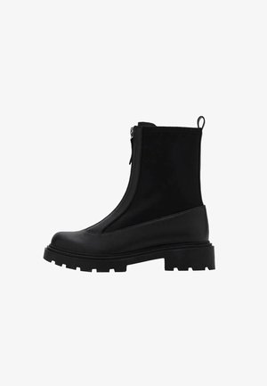 Svart ankelboot med en slät ovandel, blixtlås och kraftig gummisula med djupa spår, designad för hållbarhet och grepp.