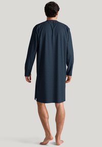 Nightgown lungo blu navy con motivi geometrici bianchi, lunghezza al ginocchio, taglio dritto, fessure laterali e texture di tessuto morbido.