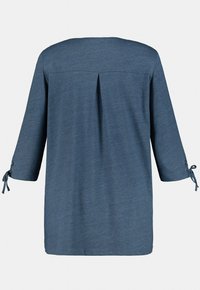 Blå, långärmad topp med en avslappnad passform, med en veck bak och knyt detaljer på ärmarna. Tillverkad av ett mjukt, texturerat tyg.