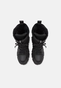 Black winter boots with a textured leather exterior, faux fur lining, adjustable laces, and a rugged rubber sole.