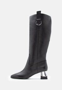 Must mustakohaline nahast saapad terava varbaga ja kromitud plokknähtusega. Ülemises osas on vunts, millel on ringikujuline riistvara aksessuaar.