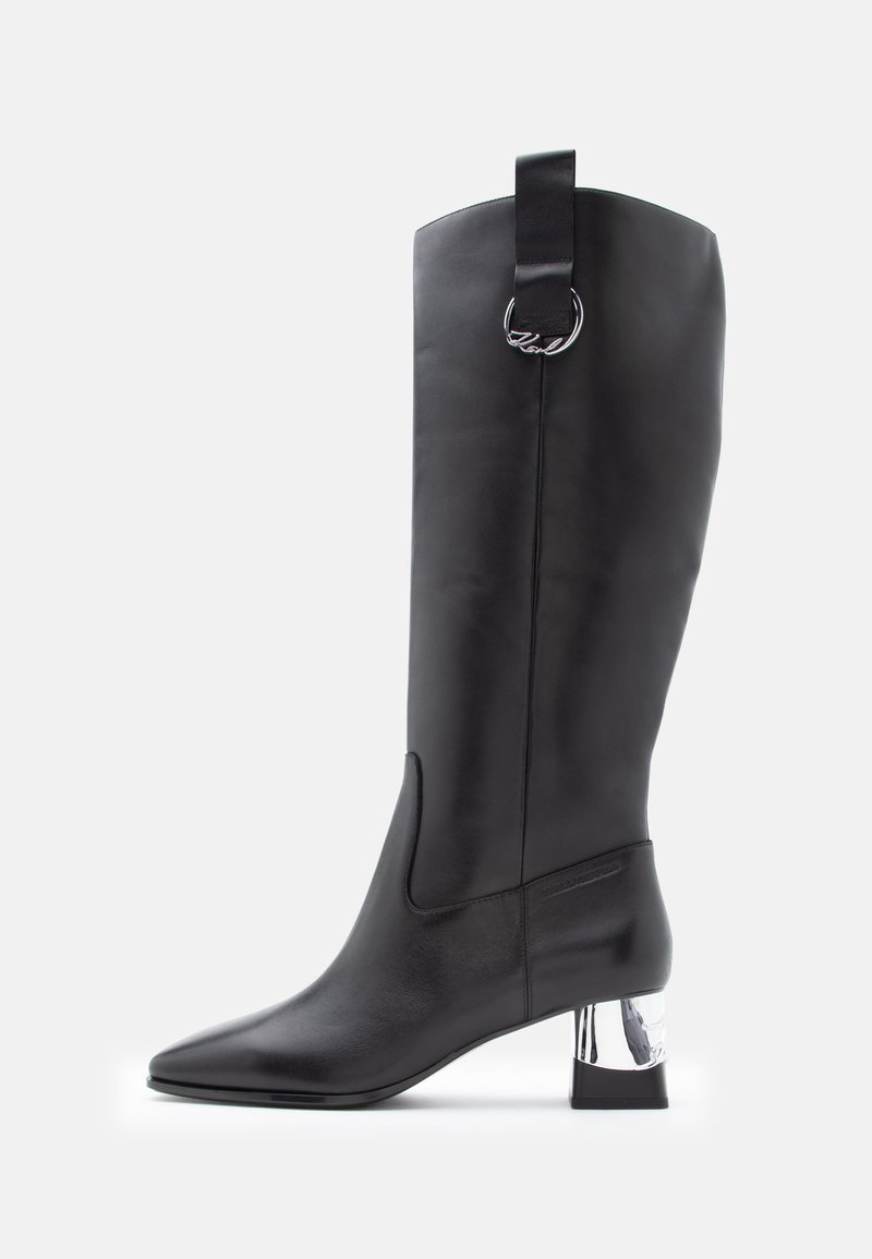 Must mustakohaline nahast saapad terava varbaga ja kromitud plokknähtusega. Ülemises osas on vunts, millel on ringikujuline riistvara aksessuaar.