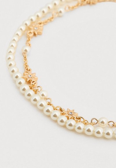 Μαργαριταρένιο κολιέ με χρυσές αλυσίδες και κρίκους σε σχήμα αστεριού, με γυαλιστερές λευκές πέρλες και κάποιες με μικρή διακοσμητική κρυστάλλινη λεπτομέρεια.