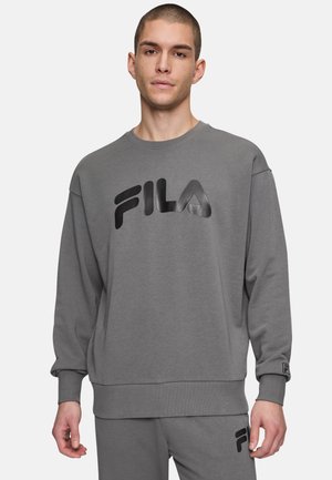 Szary sweter z miękkiego materiału, z wyraźnym czarnym logo FILA. Luźny krój z prążkowanymi mankietami i dołem. Prosty design i casualowy wygląd.