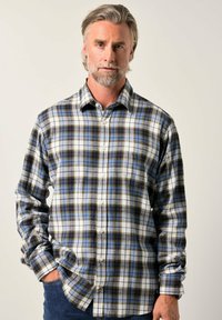 Camicia a quadri con motivi blu, bianchi e marroni; maniche lunghe, colletto e orlo arrotondato; texture di tessuto morbido.