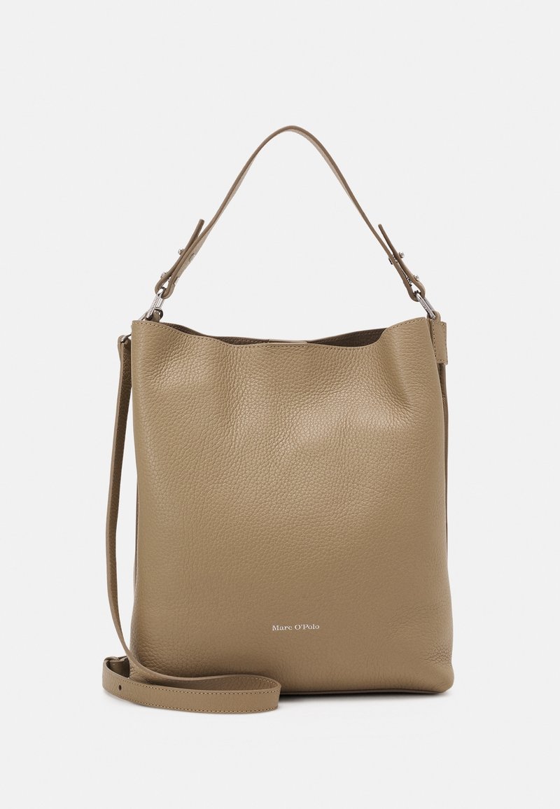 Sac seau en cuir taupe avec une surface texturée, une bandoulière ajustable et un design minimaliste. Présente un marquage discret à l'avant.