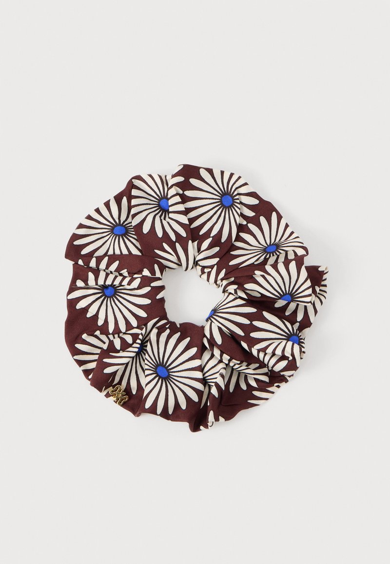 Chouchou en tissu marron avec des motifs de marguerites blanches aux centres bleus, présenté sur un fond clair uni.