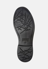 Black shoe sole with irregular crisscross tread patterns, "Camper" brand logo, size 42, and an "X8 Extra Light" label on a white background.