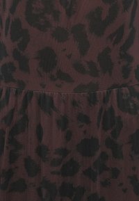 Burgundia kangas musta leopardimustriga, millel on tekstureeritud pind ja kokku volditud vöökoht.