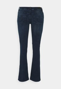 Jeans acampanados de color azul oscuro, hechos de denim, con cinco bolsillos y detalles de costura visibles. La textura es suave con un ligero estiramiento.