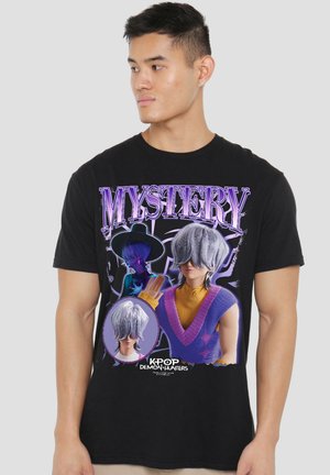 Young man wearing a black T-shirt with "MYSTERY" and K-pop Demon Hunters characters with silver hair and purple clothing.
