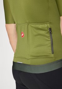 Kurzärmeliges Fahrradtrikot aus olivgrünem Stoff, mit strukturierten Streifen, einer hinteren Reißverschlusstasche und einem kontrastierenden dunkelgrünen Bündchen am Saum.