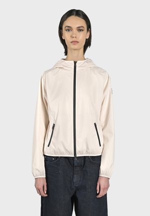 Giacca leggera rosa pallido con zip, cappuccio, cerniera nera e tasche laterali. Presenta polsini elasticizzati e un design cropped.