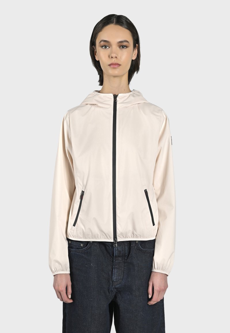 Giacca leggera rosa pallido con zip, cappuccio, cerniera nera e tasche laterali. Presenta polsini elasticizzati e un design cropped.