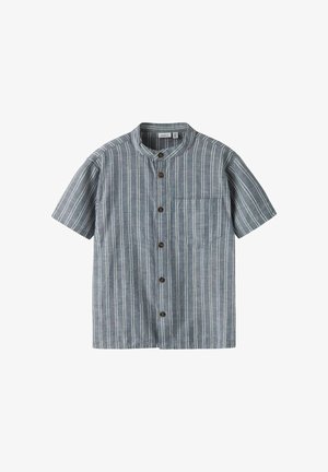 Kortærmet skjorte i et blåt og hvidt stribet mønster. Har en rund krave, en forlommer og brune knapper. Blødt stof.