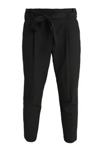 Mustat housut, jotka on valmistettu sileästä kankaasta. Niissä on sidottava vyö, laskokset ja kapenevat lahkeet.