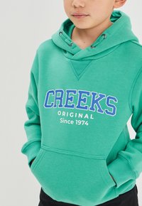 Creeks Jersey con capucha - green