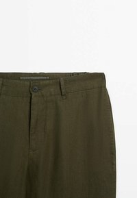 Pantaloni in lino verde oliva con frontale liscio, chiusura con un solo bottone e un tessuto testurizzato con un leggero lucido.