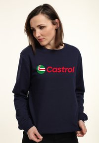 Sudadera de cuello redondo azul marino hecha de algodón con mangas largas, que presenta un gran logo de Castrol en verde y rojo en la parte frontal.
