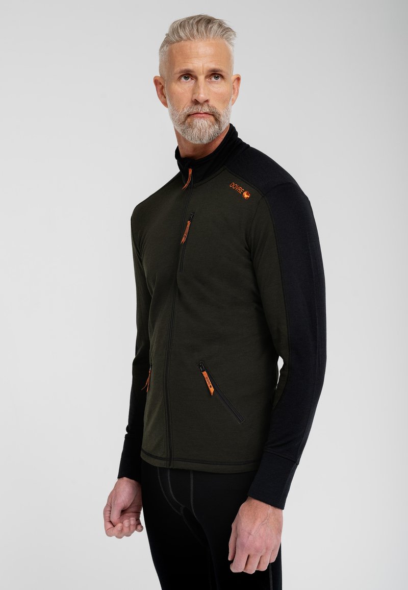 Oliven grønt lynlåsjakke med sorte ærmer, der har orange lynlåsændere og logo. Struktureret stof med tætsiddende design og to sidelommer.