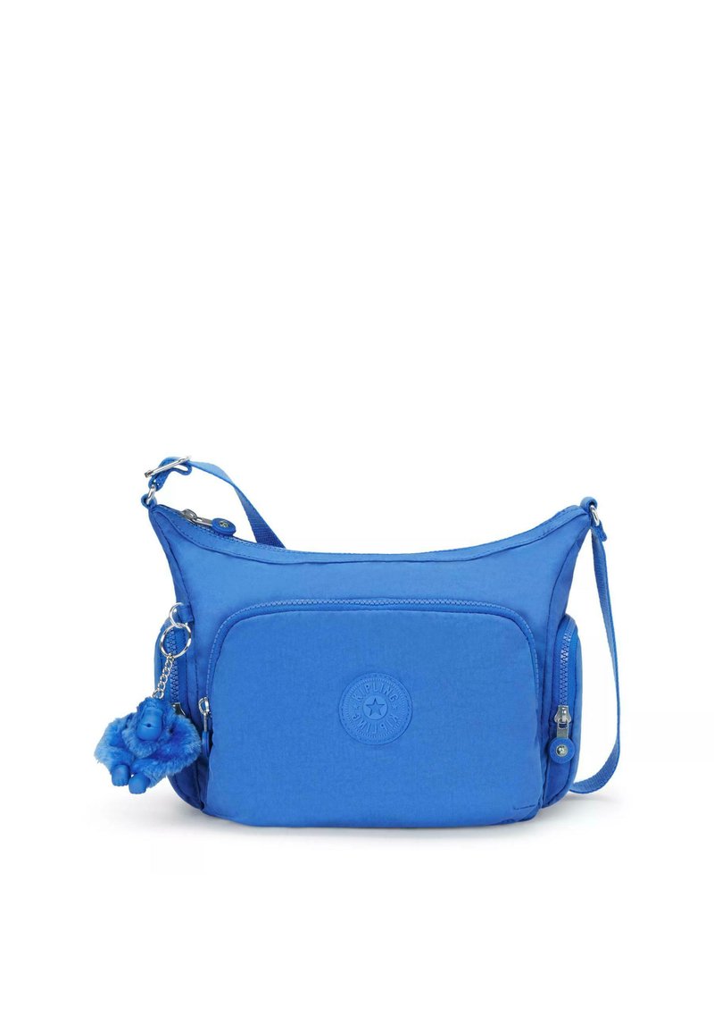 Royal blue crossbody bag with a textured finish, featuring a zippered compartment, a circular logo, and a furry blue monkey keychain.